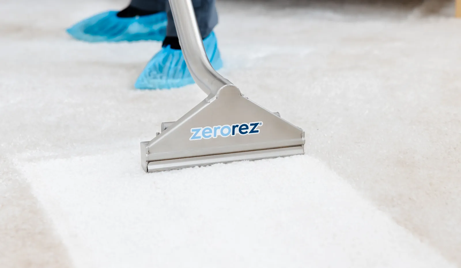 Professional carpet cleaning using Zerorez machine revealing a bright, clean carpet surface.