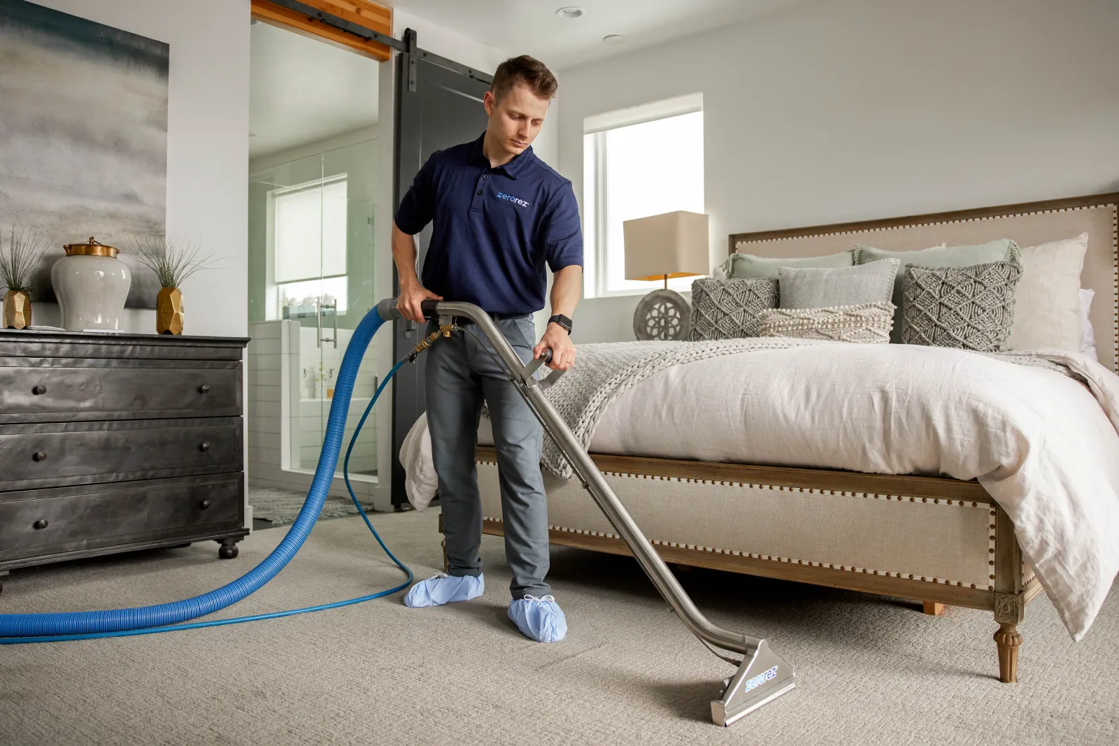 carpet cleaning technician steam cleaning carpet in bedroom