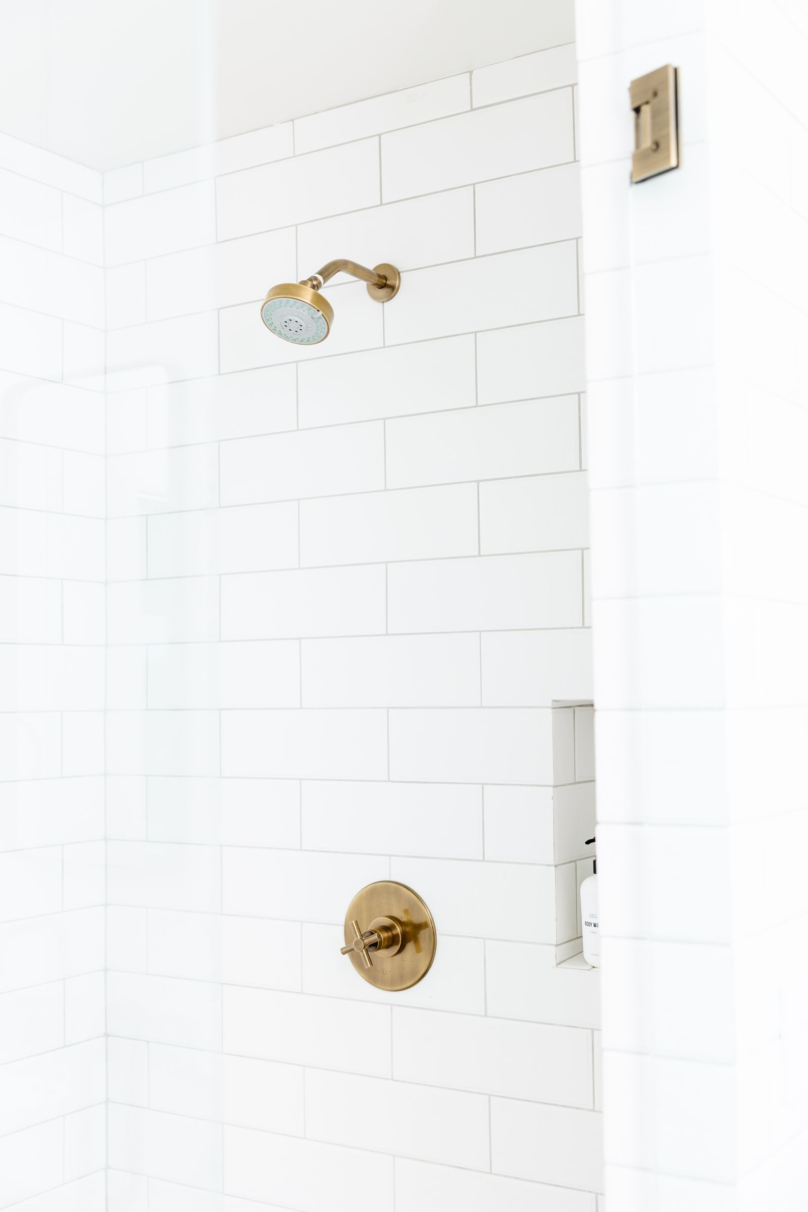 white subway tiled glass enclosure shower to illustrate why grout cracks in showers
