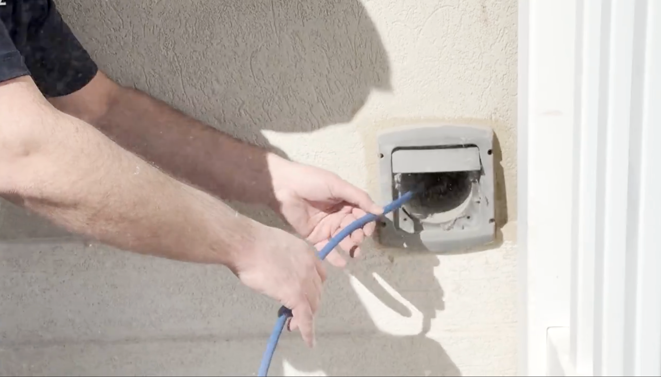 Zerorez technician cleaning a dryer vent hose from the outside of the house